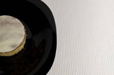 Ev yapımı tereyağı beyaz pasta siyah bir plaka üzerinde