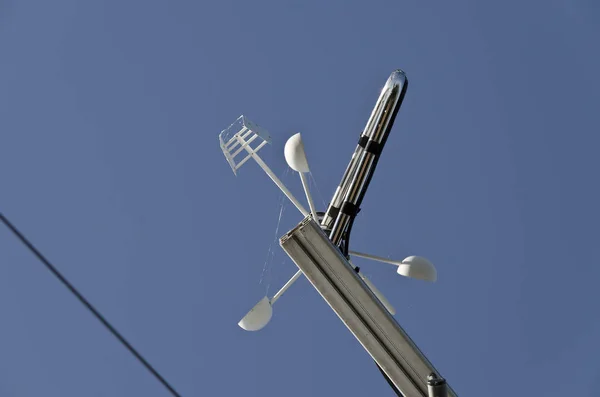 Anemometr nebo větrná korouhvička na modré obloze — Stock fotografie