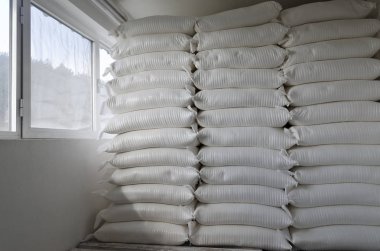 Üç depo modern fabrikasında büyük çuval yığınları