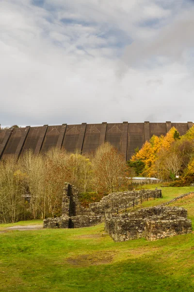 Ruined lead mine buildings with dam in distance — Stock Photo, Image