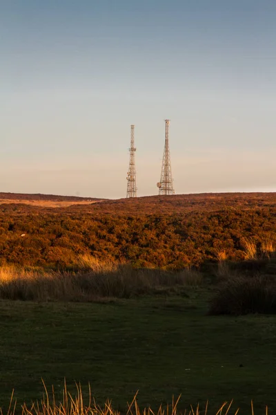 Lumière du soir au sommet de la colline avec mâts radio — Photo