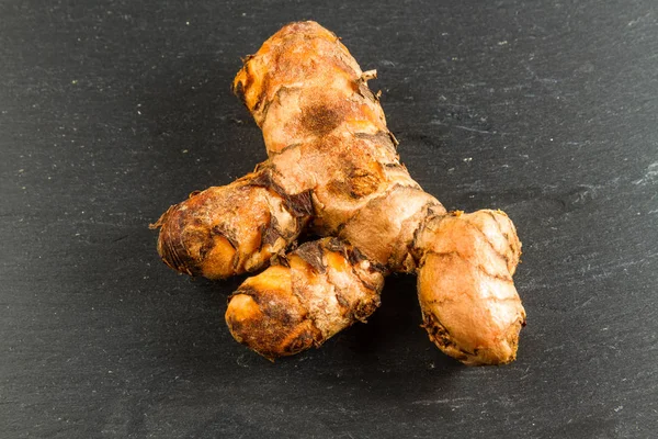 Turmeric root on dark slate background — Stock Photo, Image