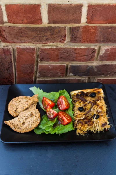 Pissaladiere französische Zwiebeltorte mit Salat und Brot — Stockfoto