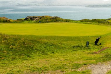 Golf Sahası yeşil deniz arka plan ve golf çanta içinde.