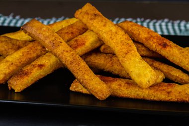 Koyu arkaplanda ev yapımı peynirli pipetler, yan görünüm.