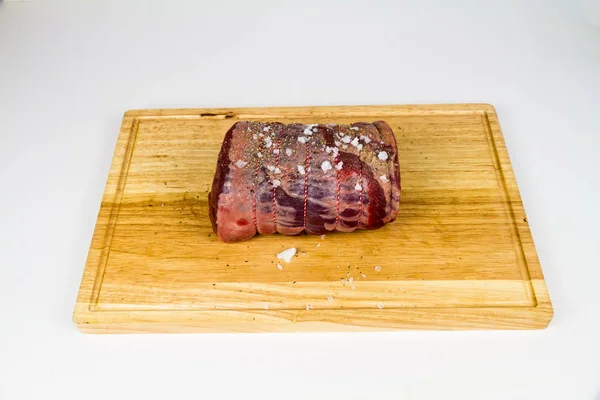 Wołowina toczona na drewnianej desce rozdrabniającej przyprawionej morzem — Zdjęcie stockowe