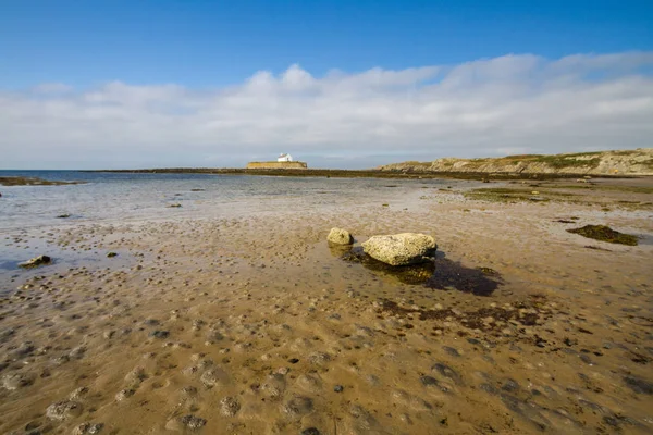 Havsstrand med kyrka i havet i fjärran på solig morgon. — Stockfoto