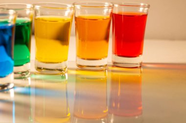 Doğal ışıkta yansımalı renkli tatlı bardakları.