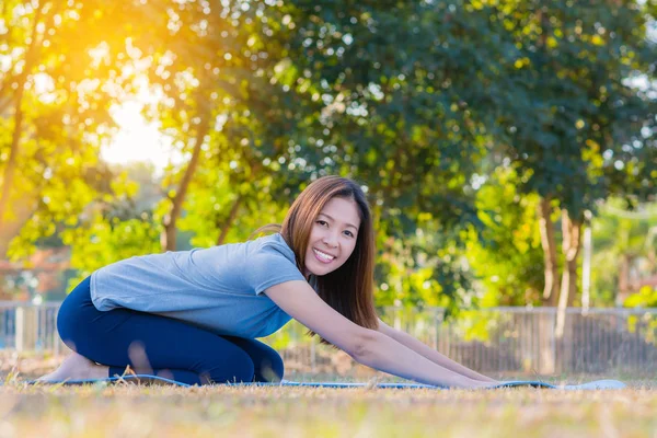 Yoga pratik, kolay poz Parkı'nda oturan genç Asyalı gülümseyen kadın.