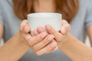 Kahve fincanı tutan eller kadın.