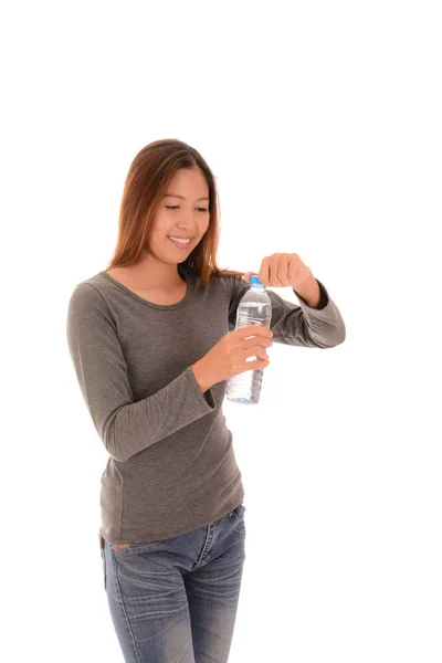 Mujer casual sonriente está abriendo una botella de agua en la espalda blanca — Foto de Stock