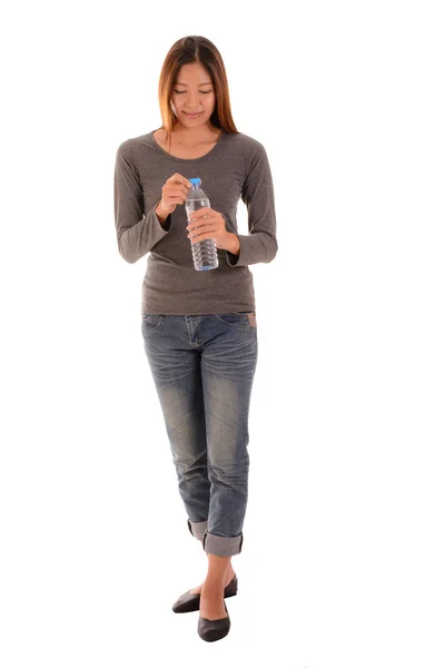 Mujer casual feliz de pie y abrir una botella de agua en w — Foto de Stock