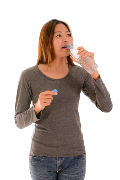 Mujer casual bebiendo agua sobre fondo blanco . — Foto de Stock