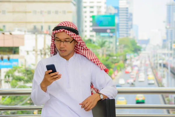 Arabisk affärsman använder smartphone utomhuspool med staden ba — Stockfoto