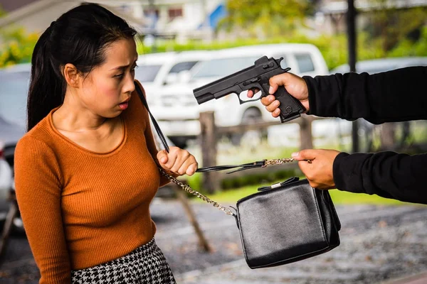 Ladrão está ameaçando mulher.Ladrão está roubando mulher por arma . — Fotografia de Stock