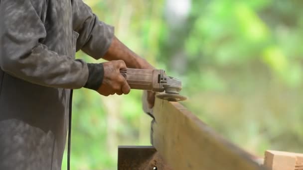 Truhlářem pracuje s elektrická pračka a zpracovává dřevěné výrobky. Tesař s kapesní elektrická pračka v rukou na dřevě. — Stock video
