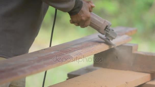 Joiner działa z elektrycznym scrubber i przetwarza produkty drewniane. Stolarz z chwytak elektryczny scrubber w ręce na wyroby z drewna. — Wideo stockowe