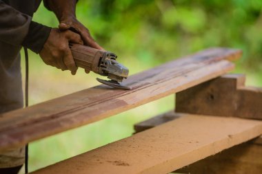 İşçi el elektrik süpürgesi ile ahşap tahta ovma.