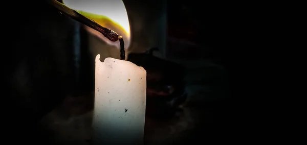 Одна свеча освещена на черном фоне — стоковое фото