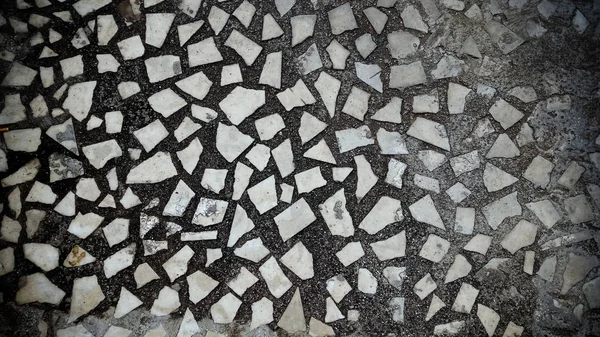 Döşeme dekoru. Terrazzo mermer parçaları, doğal taş, kuvars, cam ve kırık kiremitleri birleştirerek yapılır. Mutfak ve küvetlerin yüzeyinde parmak izi var. Bej renginde kusursuz desen.