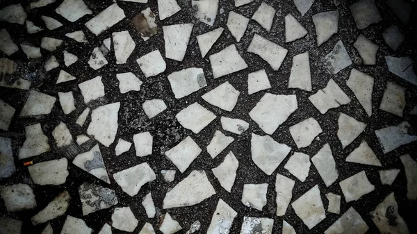 Döşeme dekoru. Terrazzo mermer parçaları, doğal taş, kuvars, cam ve kırık kiremitleri birleştirerek yapılır. Mutfak ve küvetlerin yüzeyinde parmak izi var. Bej renginde kusursuz desen.