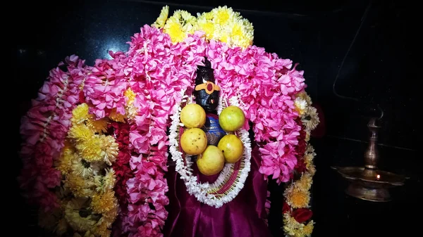 Çiçeklerle süslenmiş Sri Durgai Amman heykeli.