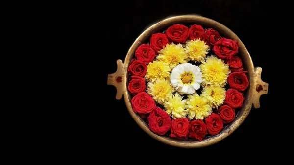Indian flower decoration in holy water. It's a Hindu religion to pray to the god with the beautiful flower decoration