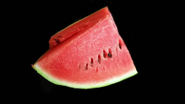 Dilimleri siyah arkaplanda izole edilmiş karpuz