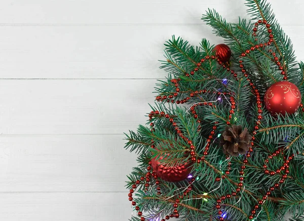 Decoración de Año Nuevo. Árbol de Navidad verde con bolas rojas y cuentas sobre un fondo de madera blanca. Tarjeta de Año Nuevo. Tarjeta de Navidad . —  Fotos de Stock