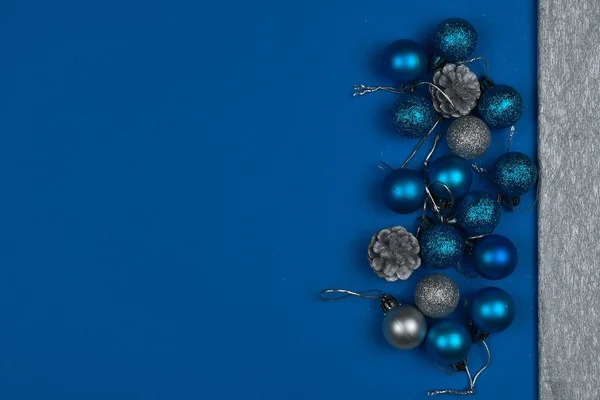 New Year\'s blue  balls and cones on a blue background. Place for an inscription. Card. Christmas. 2020 color. The trend of the year.