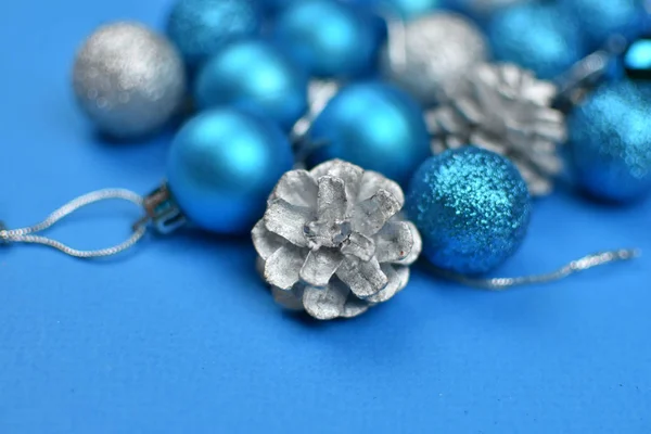 Χριστουγεννιάτικα μπλε και ασημένια μπαλάκια και κώνους σε ασημί αλουμινόχαρτο. Χριστούγεννα έννοια του νέου έτους. — Φωτογραφία Αρχείου