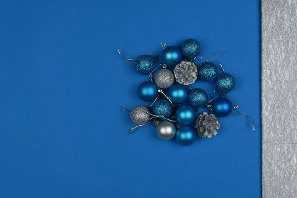 2020 color. The trend of the year.  New Year's blue and silver balls and cones on a blue background. Place for an inscription. Card. Christmas.