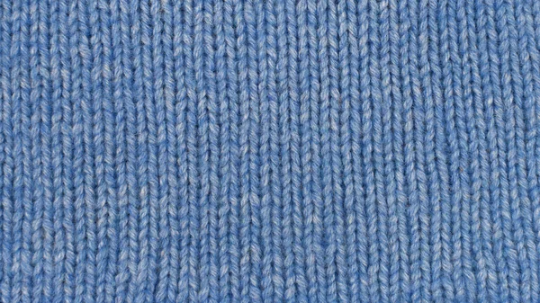 Knitted pattern as background. Blue knitted fabric texture. Hand knitting.