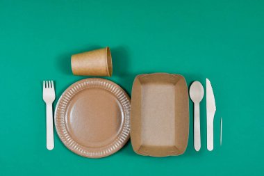 Sıfır atık, çevre dostu, tek kullanımlık, karton, yeşil arka planda kağıt kaplar.