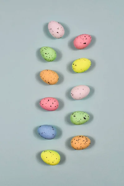 A row of Easter eggs on a yellow background. Easter concept. View from above. Place for an inscription. . Close-up. Vertical row. — 스톡 사진