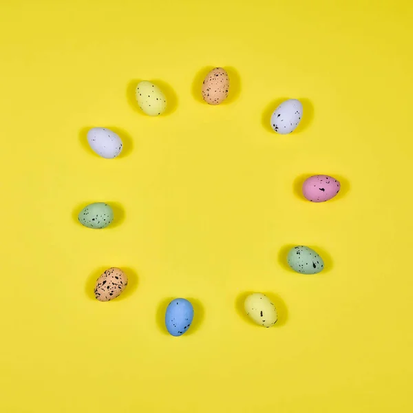 Œufs de Pâques disposés en cercle sur un fond jaune. Vue d'en haut. La base de la carte postale . — Photo
