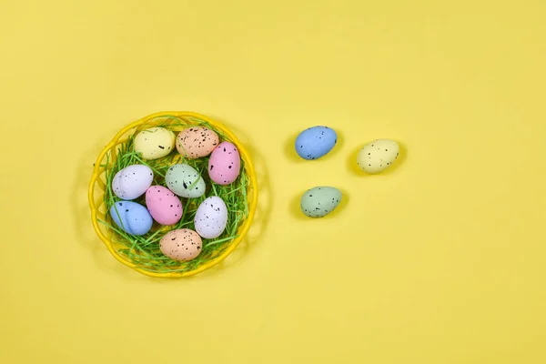 Œufs de Pâques multicolores dans une assiette jaune sur fond jaune. Place pour une inscription. Vue d'en haut. Concept de Pâques . — Photo