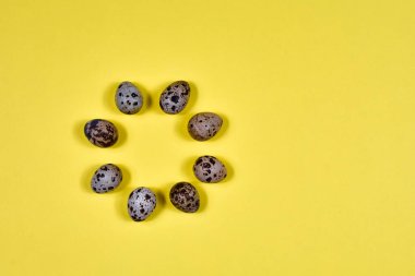 Paskalya yumurtaları sarı arka planda daireler çizer. Yukarıdan bak. Kartpostalın temeli.