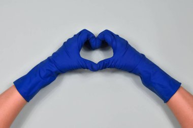 Kauçuk koruyucu eldivenlerle çalışan eller kalbi gösterir. Bahar başı veya düzenli temizlik. Temizlik kavramı.