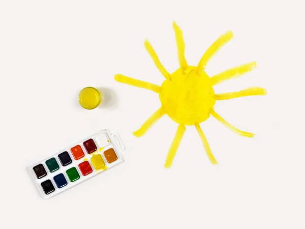 Солнце окрашено в желтый цвет на листе белой бумаги. Детское творчество. Детский рисунок . — стоковое фото