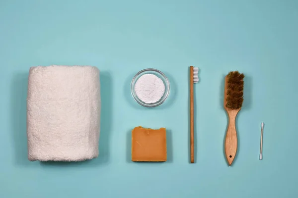 Zero waste concept. Toothbrush, tooth powder, towel, soap and brushes on a blue background. View from above.