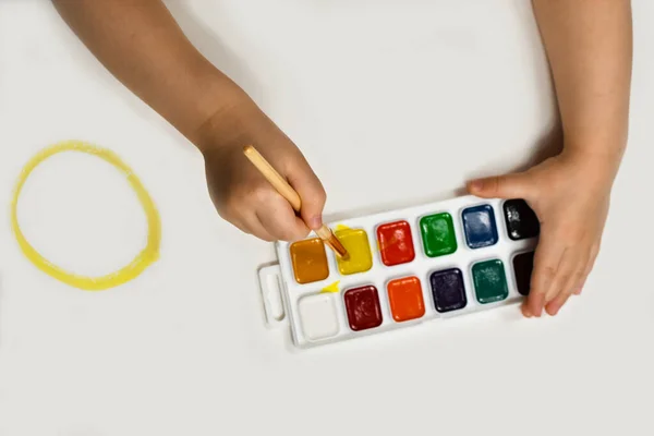 Le mani da bambini sono dipinte con un pennello e acquerelli. Creatività dei bambini, pittura, sviluppo precoce . — Foto Stock