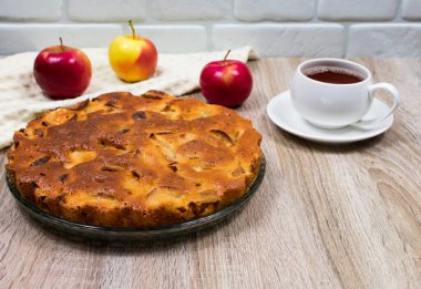 Ev yapımı elmalı turta, bir tabakta, ahşap bir masada, yemeye hazır. Yukarıdan görüntüle.