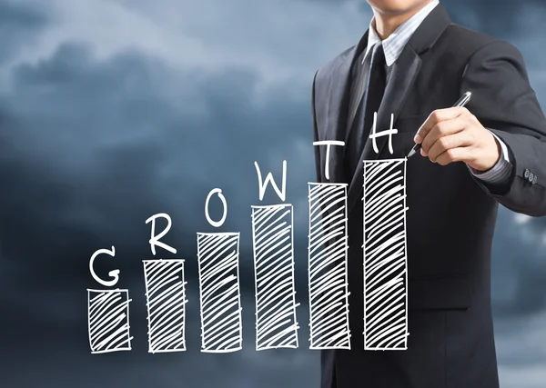 Business man writing growth chart concept
