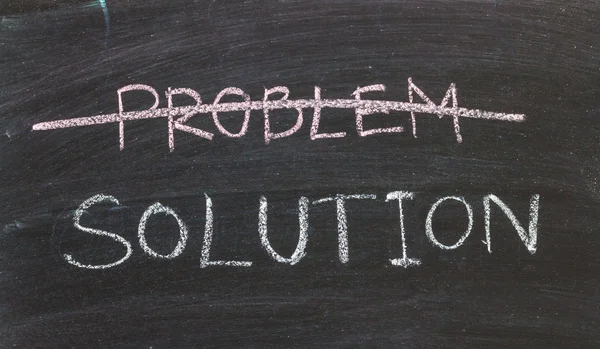 Problems Solutions handwritten with white chalk on a blackboard — Stock Photo, Image