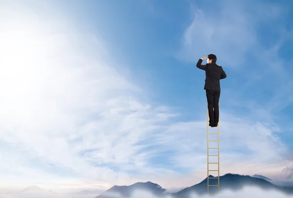 Biznesmen, stojąc na drabince na niebie — Zdjęcie stockowe