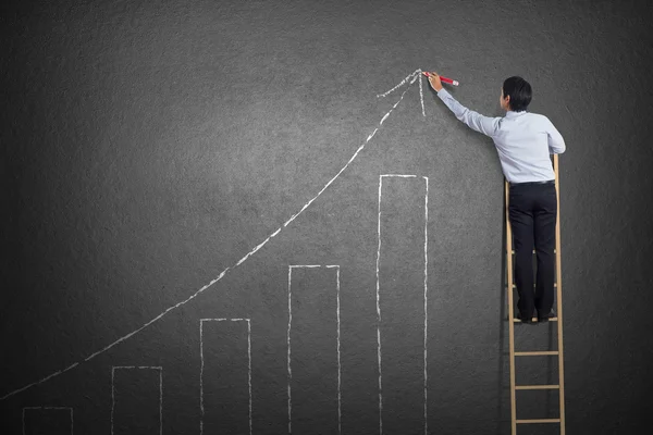 Business man standing on ladder drawing growth chart on wall — Stock Photo, Image