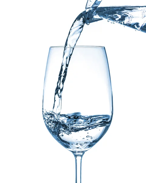 Wasser auf ein Glas auf weißem Hintergrund gießen — Stockfoto