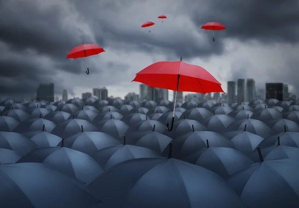Красный зонтик выдающийся из других, выбранная концепция — стоковое фото