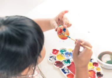 Asyalı çocuk easter egg boyama